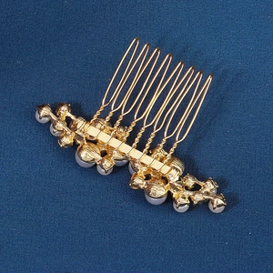 Elegant gold bridal hair comb with pearls and rhinestones on deep blue background