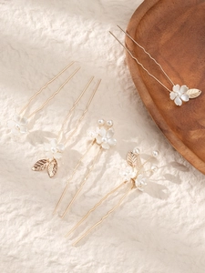 Detail of handmade bridal hair pins set with white resin flowers and faux pearls