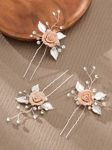 Detail of pink ceramic rose hair pins with pearls and crystals for bridal styling