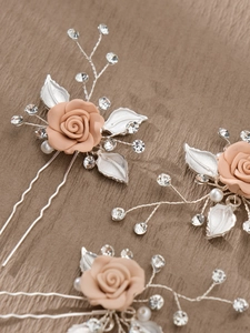 Close-up of handmade bridal hair comb with pink resin roses and sparkling pearls
