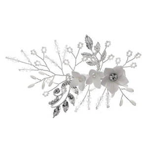 Détail de fleurs en résine blanche et perles de cristal sur un peigne de mariée argenté