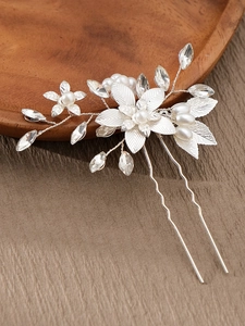Macro detail of bridal hair comb with silver alloy leaves, pearls, and faceted crystals