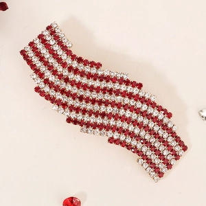 Elegant exotic hair clip with red and white rhinestones on a gold metal base