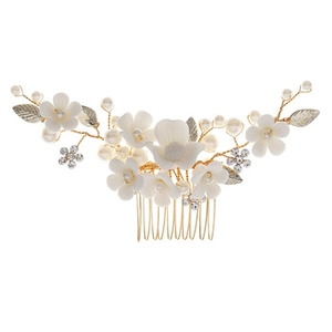 Détail d'un peigne de mariée avec fleurs blanches, perles et cristaux brillants