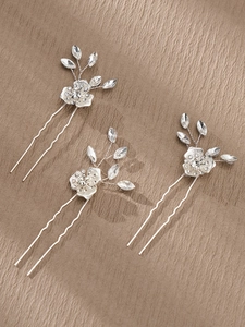 Detailed view of three silver bridal hair pins with crystal flowers and leaf motifs