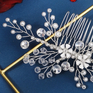 Macro detail of handmade bridal hair comb with pearls, crystals and floral silver wire
