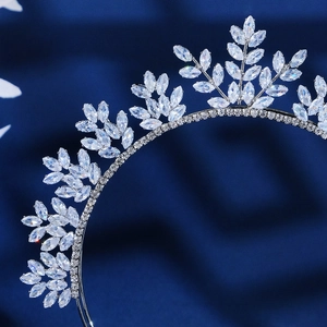 Diadema de corona plateada de lujo con hojas de circón sobre terciopelo azul oscuro