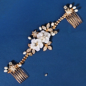 Exquisite bridal gold hair combs with white flowers, pearls, and crystals for wedding styling