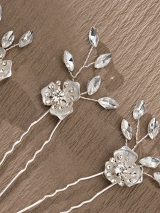 Detail of handmade bridal hair comb with silver flower and sparkling teardrop rhinestones