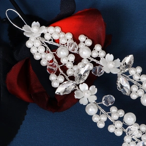 Close-up of handmade bridal headband with white pearls, crystals and flower details