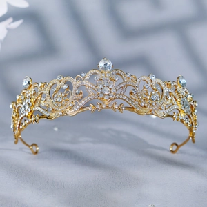 Détails d'une couronne de mariée baroque dorée avec des volutes en alliage et strass brillants