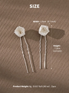 Detail of white ceramic flower hair pins with crystals and silver wavy metal combs