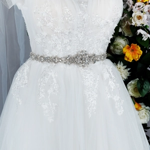 Close-up of bridal dress with exquisite floral lace and a handmade pearl rhinestone belt