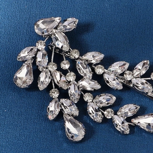 Silver leaf-shaped bridal hair clip with marquise rhinestones on blue fabric