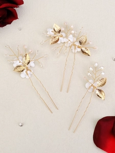 Detail of handmade bridal hair pins with gold leaves, white flowers and pearls