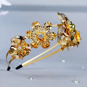 Macro shot of gold metal bridal headband showing intricate floral petals and sparkling rhinestones