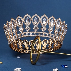 Close-up of vintage baroque golden crown with intricate rhinestones on blue background