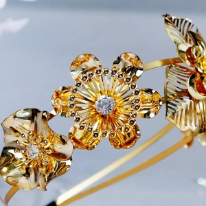 Vintage golden floral bridal headband with layered metal petals and crystal accents