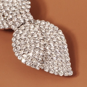 Macro detail of leaf-shaped hair clip with shimmering pave-set rhinestones in silver metal