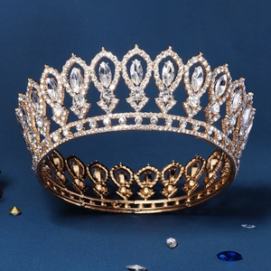 Baroque gold bridal crown with white rhinestones and pear-shaped crystals on blue background