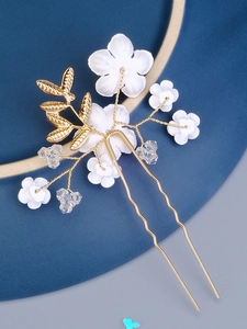 Detail of bridal hair comb with white ceramic flowers, gold leaves and crystal beads