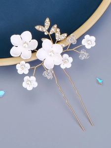 Detailed close-up of bridal hair comb with ceramic flowers, pearls and crystals
