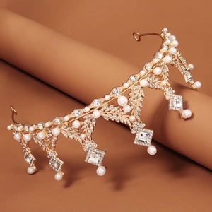 Couronne baroque dorée avec perles et strass posée sur un support minimaliste