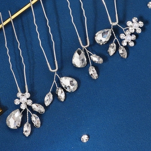Gros plan détaillé de quatre épingles à cheveux argentées avec strass et perles blanches