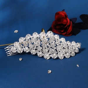 Close-up of bridal crystal hair comb with pearls and rhinestones on blue fabric
