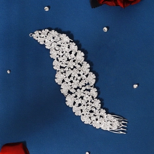 Detailed close-up of a silver bridal hair comb with shimmering rhinestones on blue background
