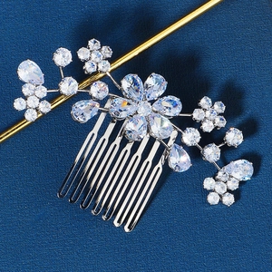 Detailed macro view of bridal silver hair comb with floral zircon crystals on blue background