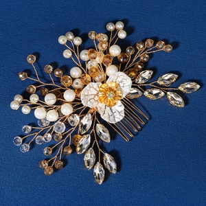 Detail of bridal hair comb with pearls, crystals and white flower on blue background
