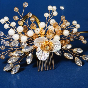 Detailed macro view of handmade bridal hair comb with pearls and golden floral crystals