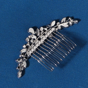 Détail d'un peigne à cheveux de mariée argenté avec motifs de feuilles et pierres zircons