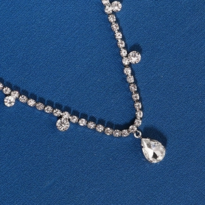 Close-up of sparkling water-drop rhinestones and silver fringe tassel hair accessory