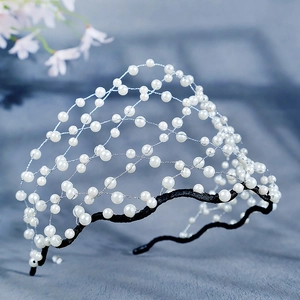 Détail d'un serre-tête de mariée avec perles délicates et structure en maille argentée