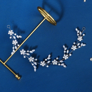Elegant bridal hair vine with silver floral crystals on a navy textured background
