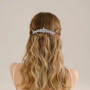 Peigne à cheveux de mariée avec feuilles argentées et cristaux sur cheveux bouclés