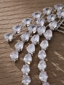 Detail of bridal hair comb featuring layered pear-cut zircon stones and silver plating