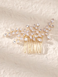 Close-up of golden bridal hair comb with marquise cut zircon flowers and leaf details