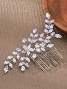 Macro detail of bridal hair comb featuring zircon flower leaves and silver tines