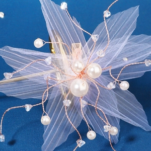 Detailed macro view of white tulle petals and rose gold wire with crystal beads