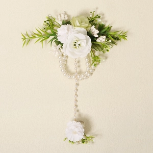 Close-up of pearl hand chain with silk flowers and daisy ring for wedding accessory