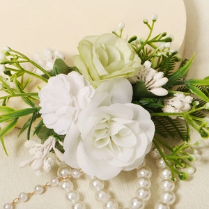 Close-up of elegant handmade floral bracelet with white roses and pearls on a beige stand