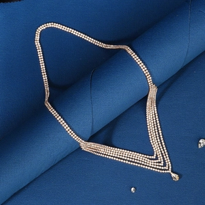 Detail of multi-layer rhinestone hair chain with a crystal water drop pendant on blue fabric