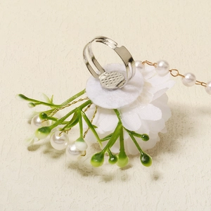 Close-up of adjustable silver ring with white fabric flower and delicate pearls