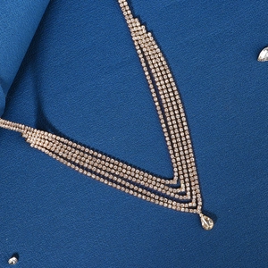 Close-up of golden multi-layer crystal hair chain with a large pear-shaped rhinestone drop