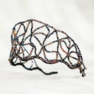 Macro shot of handmade net headband with colorful crystals and black wire lace texture