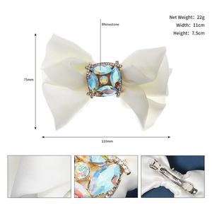Detail of white satin bow hair clip with colorful rhinestones and spring clip sizing