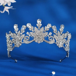 Silver flower bridal crown with white rhinestones on dark blue fabric background